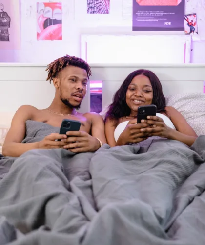 пара в постели с телефонами